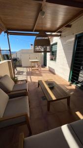 eine Terrasse mit einem Holztisch, Stühlen und einem Tisch in der Unterkunft Atico Canet de Berenguer in Canet d'en Berenguer