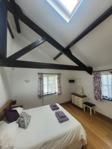 a bedroom with a white bed and two windows at Long Linhay in Woolacombe