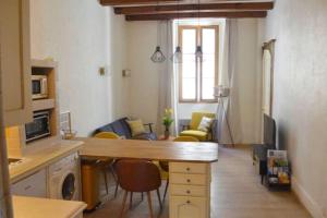 a kitchen and living room with a table and chairs at Le Chateau in Évian-les-Bains