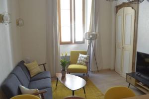 a living room with a blue couch and yellow chairs at Le Chateau in Évian-les-Bains