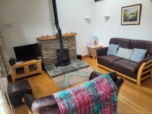 a living room with a couch and a fireplace at Long Linhay in Woolacombe