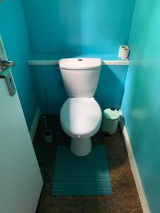 a bathroom with a toilet in a blue room at Évasion du préhaut in Tournehem