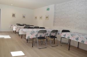 uma fila de mesas e cadeiras num quarto em Albergue Gares em Puente la Reina