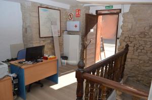 una oficina con escritorio y un ordenador en una escalera en Albergue Gares en Puente la Reina