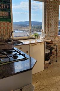een keuken met een fornuis, een wastafel en een raam bij Piso con vistas al mar. Apartamento Miramar in San Cibrao