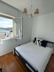 een slaapkamer met een bed en uitzicht op het strand bij Piso con vistas al mar. Apartamento Miramar in San Cibrao