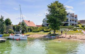 a group of people swimming in a river with a boat at 2 Bedroom Beach Front Apartment In Rydzewo in Rydzewo