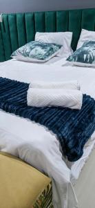 two beds with blue and white sheets and pillows at Nandoni Crystal in Thohoyandou