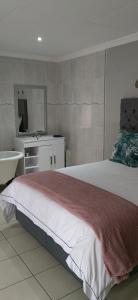 a bedroom with a large bed and a sink at Nandoni Crystal in Thohoyandou