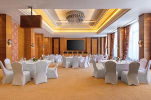 une salle de banquet avec des tables et des chaises blanches et un paravent dans l'établissement Cleopatra Luxury Resort Sharm El Sheikh, à Charm el-Cheikh 37 autres photos