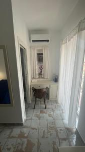 biały pokój ze stołem i oknem w obiekcie B&B Centro Storico w mieście Diamante