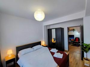 a bedroom with a large white bed and a mirror at River side apartment with terrace in Floreşti