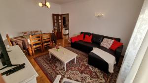 un soggiorno con divano nero e tavolo di Zinha's Guest House a Moledo