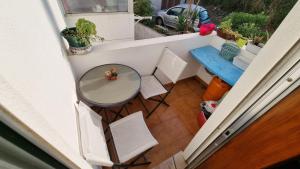 un balcón con vistas panorámicas a una mesa y sillas. en Zinha's Guest House en Moledo