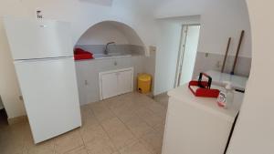 cocina con nevera blanca y fregadero en Trullo Alberobello Vacanze Desà 1 en Alberobello