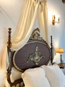卡莫納的住宿－Hotel Servilia，一张带白色窗帘的天蓬床