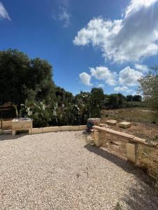 a park bench sitting on a gravel road at Lamia Millanta in Villanova di Ostuni