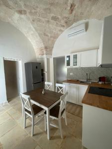 a kitchen with a table and chairs in a room at Lamia Millanta in Villanova di Ostuni