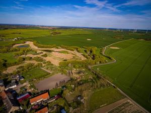 an aerial view of a green field and a river at Ka:Ma Hof Uckermark in Carmzow