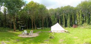 Plouray的住宿－tente nature，田野上的白色帐篷,配有两把椅子