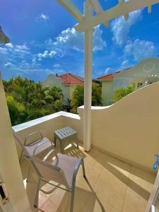 a balcony with chairs and a table and a fence at Tranquil Townhome, close to beach & dining in Saint James