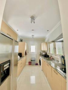a large kitchen with a refrigerator and a sink at Tranquil Townhome, close to beach & dining in Saint James