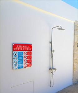 een badkamer met een douche met een bord aan de muur bij VILLA HALEPOURI in Chania