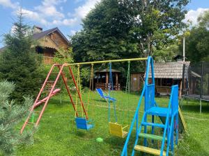 a yard with a playground with two swings at Oselia Mandrivnykiv in Tukhlya