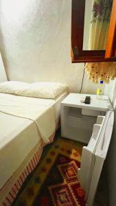 a small room with a bed and a table at Ayvalık Aygün pansiyon in Ayvalık