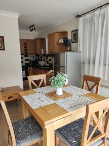 una cocina con una mesa de madera con un jarrón de flores. en Терасите - Къща 4 en Ribarica