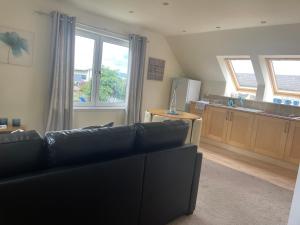 a living room with a couch and a kitchen at Robin's Rest in Auchterarder