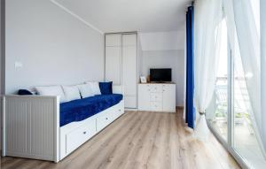 a bedroom with a bed with a blue blanket at 1 Bedroom Amazing Apartment In Darlówko in Darłówko