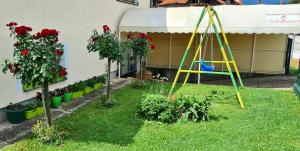 a garden with a swing in the grass at Apartman Bubamara in Arilje