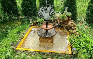 a fountain in the middle of a garden at Apartman Bubamara in Arilje