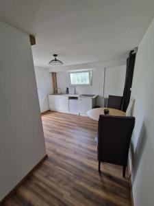 ein Wohnzimmer mit einem Tisch und einer Küche in der Unterkunft Appartement avec terrasse in La Talaudière