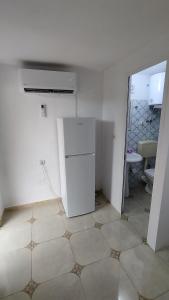 a kitchen with a white refrigerator in a room at Welcome Guest House in Shkodër