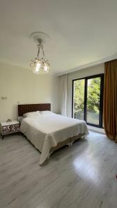 ein Schlafzimmer mit einem großen Bett und einem großen Fenster in der Unterkunft Deniz Apartment in Yalova