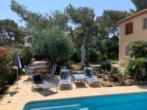 a group of chairs and a swimming pool next to a house at Les Embruns Maison Appartement in Saint-Mandrier-sur-Mer