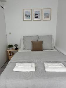 a bed with two white towels on top of it at Appart Cosy CDG Paris Parc Expo Astérix in Dammartin-en-Goële