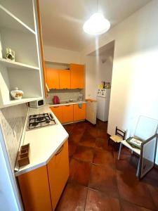 een keuken met oranje kasten en een bruine vloer bij Appartamento Cocò in Praia a Mare