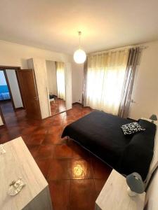 sypialnia z czarnym łóżkiem i dwoma stołami w obiekcie Appartamento Cocò w mieście Praia a Mare