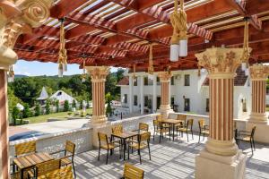 an outdoor patio with tables and chairs at Virginia Gardens in Băile Govora