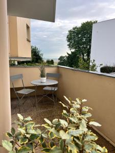 eine Terrasse mit einem Tisch und Stühlen auf dem Balkon in der Unterkunft Appart Cozy CDG, Paris, Disney, Parc Expo, Astérix in Dammartin-en-Goële