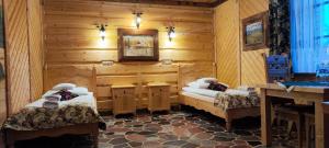 sypialnia z 2 łóżkami w drewnianym domku w obiekcie Chata Góralska i Pokoje Gościnne w Ciechocinku