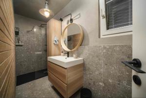 La salle de bains est pourvue d'un lavabo et d'un miroir. dans l'établissement “Moment s” Sea house Petrčane, à Petrčane