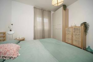 - une chambre avec un lit vert et une commode dans l'établissement “Moment s” Sea house Petrčane, à Petrčane