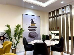 une salle à manger avec une table, des chaises et une photo dans l'établissement Staycation Loft, Lekki Phase 1, à Lekki