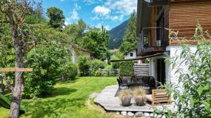 un jardín con mesa y sillas en un patio en Ferienhaus Freiheit - Modernes Haus in alpenländischem Stil für Urlaub und Workation in bester Lage am Fuß der Alpen en Oberaudorf