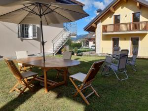 einen Tisch und Stühle mit Sonnenschirm im Hof in der Unterkunft Casa Gina in Roana