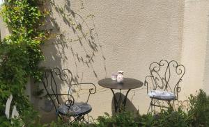 Dos sillas y una mesa con un set de té. en Belle dépendance, appartement cosy, tout confort en Montpellier